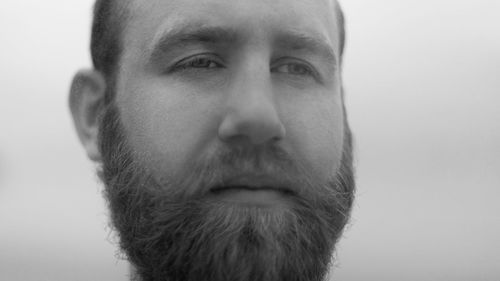 Close-up of man looking away against white background