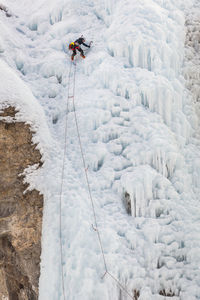 Woman climbs cliff at ice park in lake city, colorado