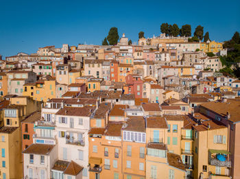 Buildings in city against clear blue sky