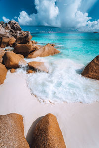 Scenic view of rocks on beach against sky