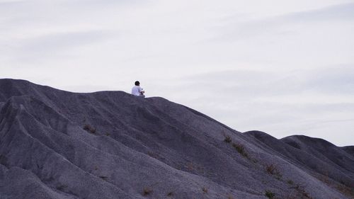 Low angle view of person on mountain against sky