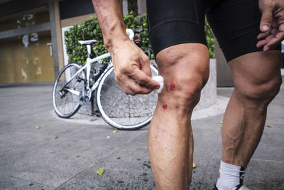 Low section of man with bicycle on street