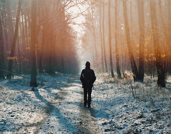 Rear view of man standing on snow covered land