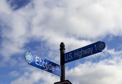 Low angle view of road sign against sky