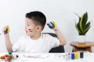 Portrait of boy holding ice cream on table