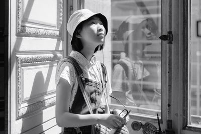 Young woman standing by window