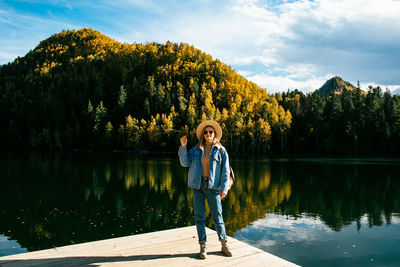 Full length of man standing by lake against sky