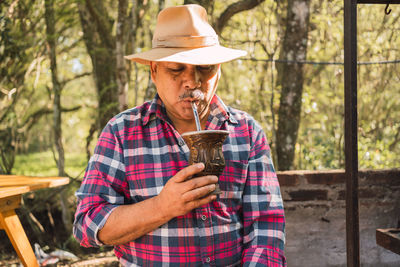 Argentinian male drinking mate from calabash gourd in countryside