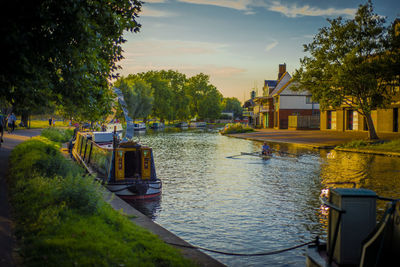 Houses by river against sky