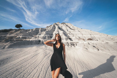 Full length of woman standing on ground against sky