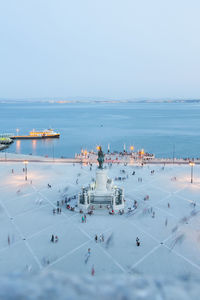 Aerial view of people on street by sea against sky