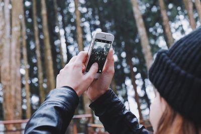 Close-up of hand holding smart phone outdoors