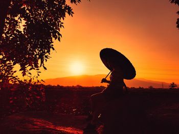 Silhouette man against orange sky during sunset