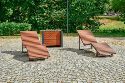 Empty chairs on footpath in park