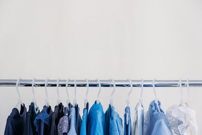 Fast fashion, sustainable fashion, minimalist wardrobe. variety of female blue clothing on hanging 