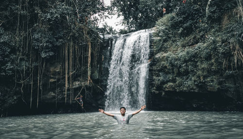 Man surfing on waterfall in forest