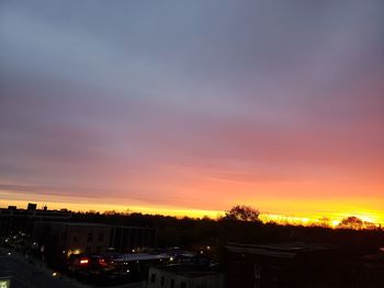 High angle view of silhouette trees and buildings against sky during sunset