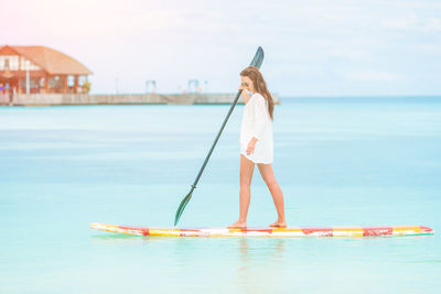 Woman standing at beach against sky