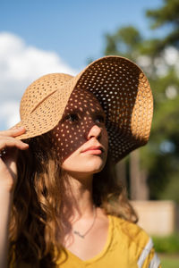 Close-up portrait of young woman wearing hat