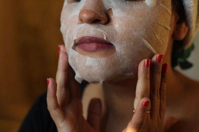 Close-up of woman using facial mask at home