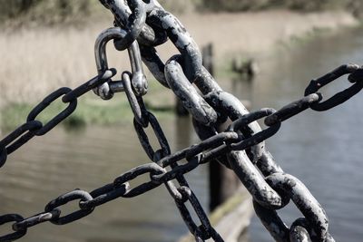 Close-up of chain against river