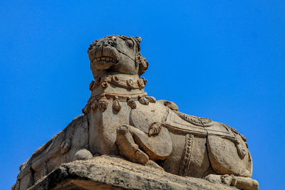 Low angle view of statue against clear blue sky