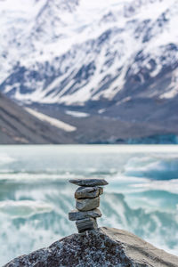 Close-up of glacier on rock at lake against sky