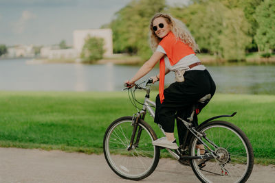 Side view of woman riding bicycle in water