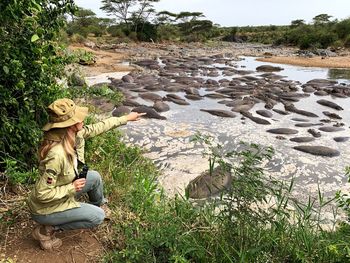 Woman sitting on rock by lake