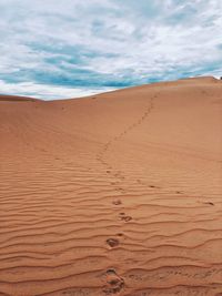 Sand dunes in desert against sky