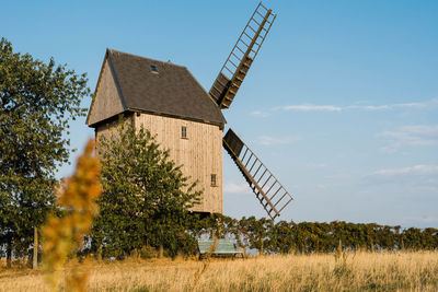 Traditional windmill on field against sky
