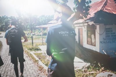 Rear view of people walking on street in city