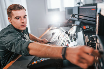 Setting the equipment. young man is indoors in the radio studio is busy by broadcast.