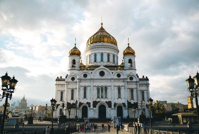 View of buildings in city against cloudy sky
