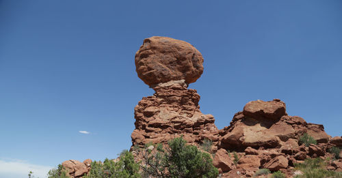 Low angle view of rock formation against clear blue sky