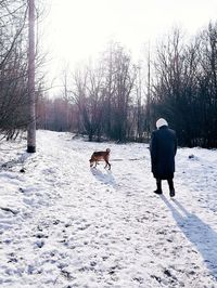 Rear view of people walking on snow covered landscape