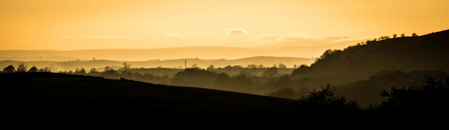 Scenic view of silhouette mountains against sky at sunset