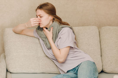 Young woman sitting on sofa at home