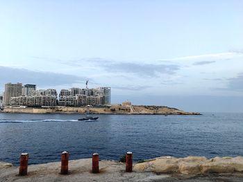 View of calm sea with buildings in background