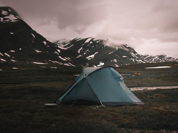 Tent against mountain and cloudy sky in swedish lapland 
