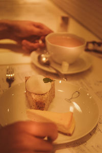 Cropped hand of woman holding food on table