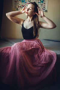 Beautiful young woman sitting at home