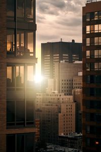 Buildings in city against sky during sunset