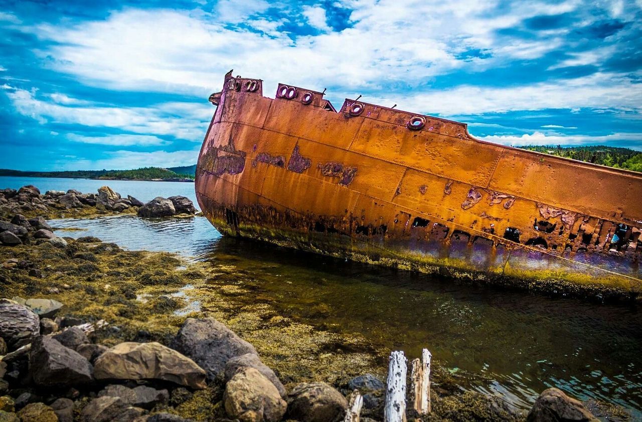 ABANDONED BOAT AT SEA AGAINST SKY