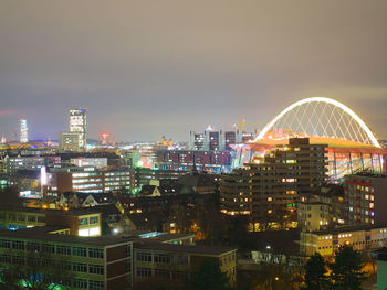 Illuminated cityscape against sky at night