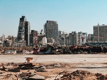 Destroyed cars from the beorut explosion with destroyed city skyline against clear sky