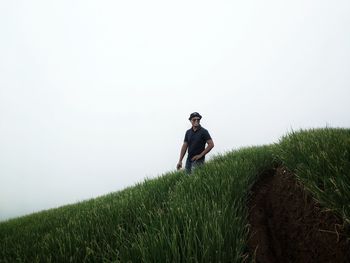 Man standing on field against clear sky