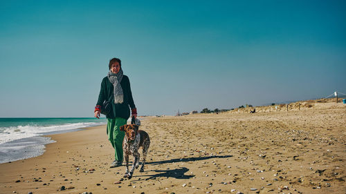 Rear view of woman standing at beach