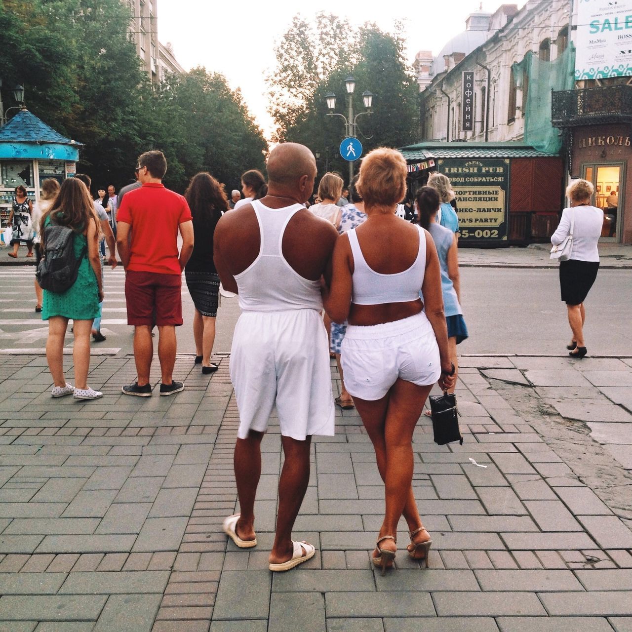 person, men, building exterior, large group of people, walking, lifestyles, street, cobblestone, leisure activity, city, city life, architecture, built structure, rear view, sidewalk, footpath, full length, casual clothing, togetherness