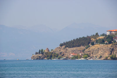 Scenic view of sea and mountains against sky